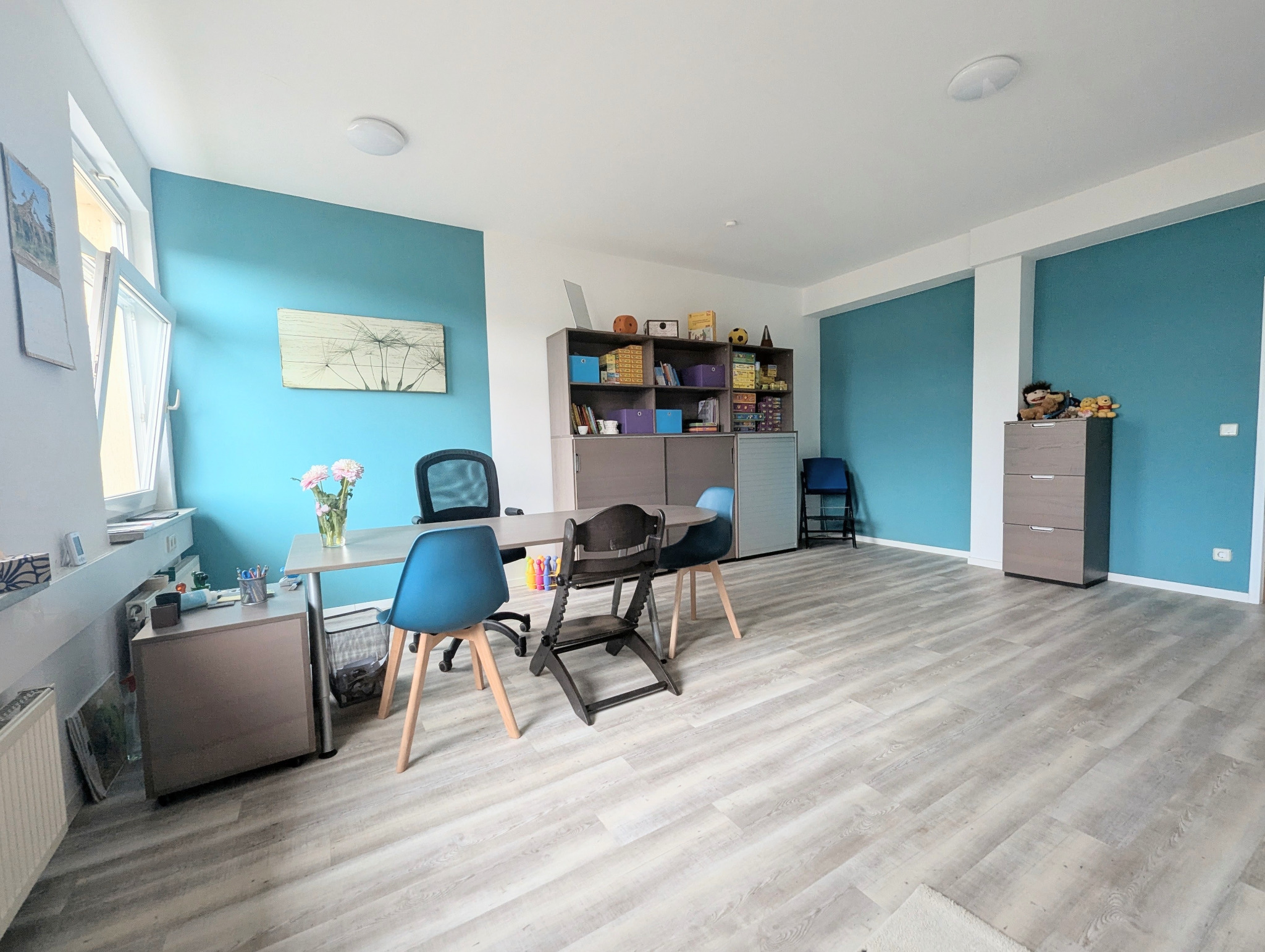 Therapieraum für Kinder mit blauer Akzentwand und Spielmaterialien